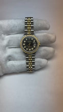 Video laden en afspelen in Gallery-weergave, Datumjust dames Rolex-horloge met zwarte diamanten wijzerplaat en gouden armband
