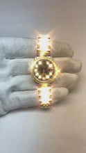 Video laden en afspelen in Gallery-weergave, Datumjust dames Rolex-horloge met zwarte diamanten wijzerplaat en gouden armband
